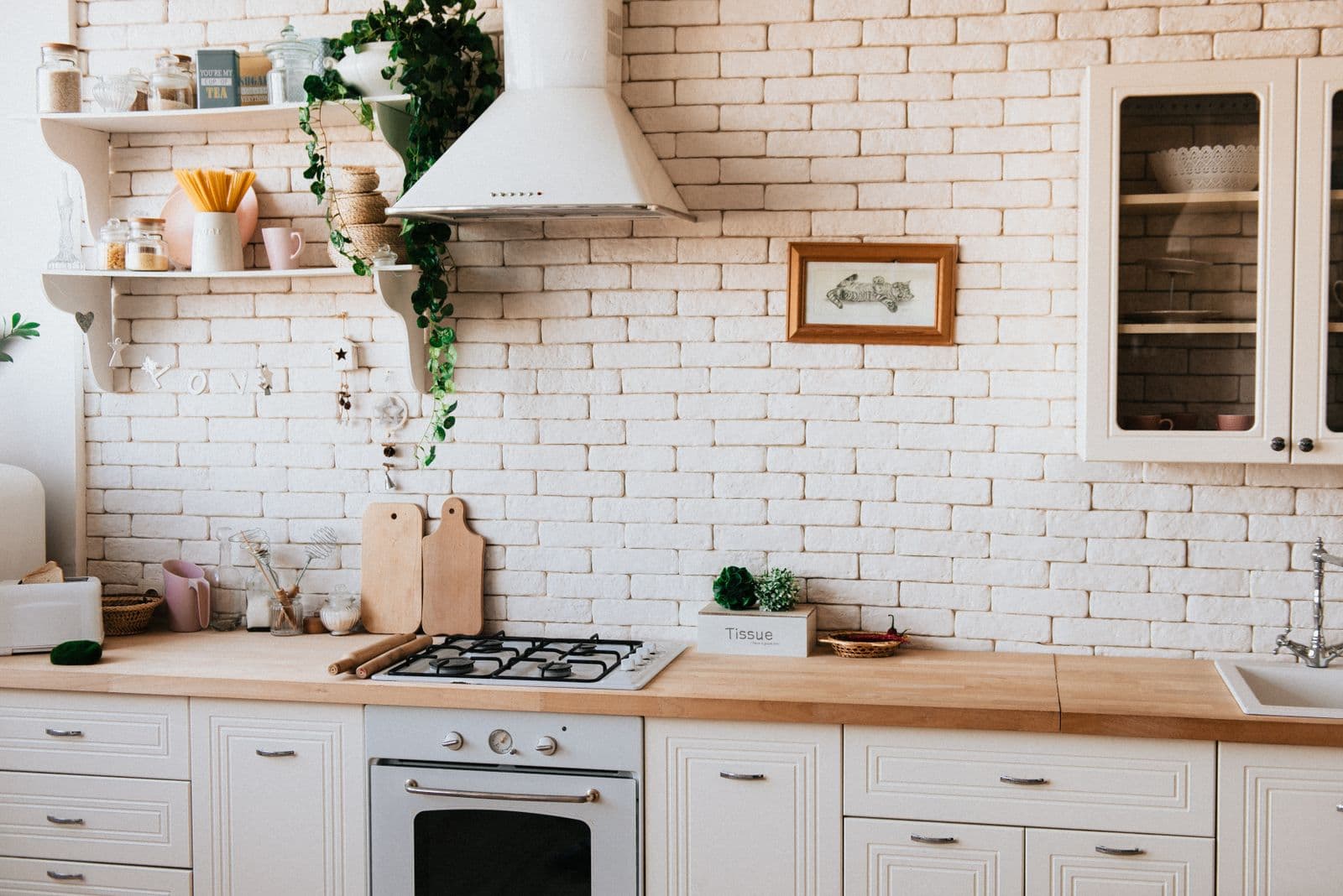 Farmhouse kitchen concept with painted brick and butcher block counters