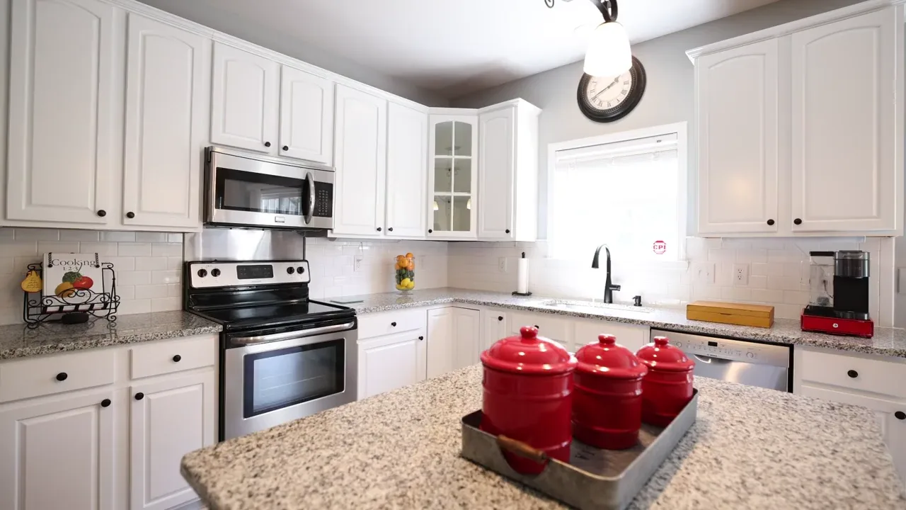 A finished luxury kitchen remodel with white cabinets and stone countertops in Arlington, VA
